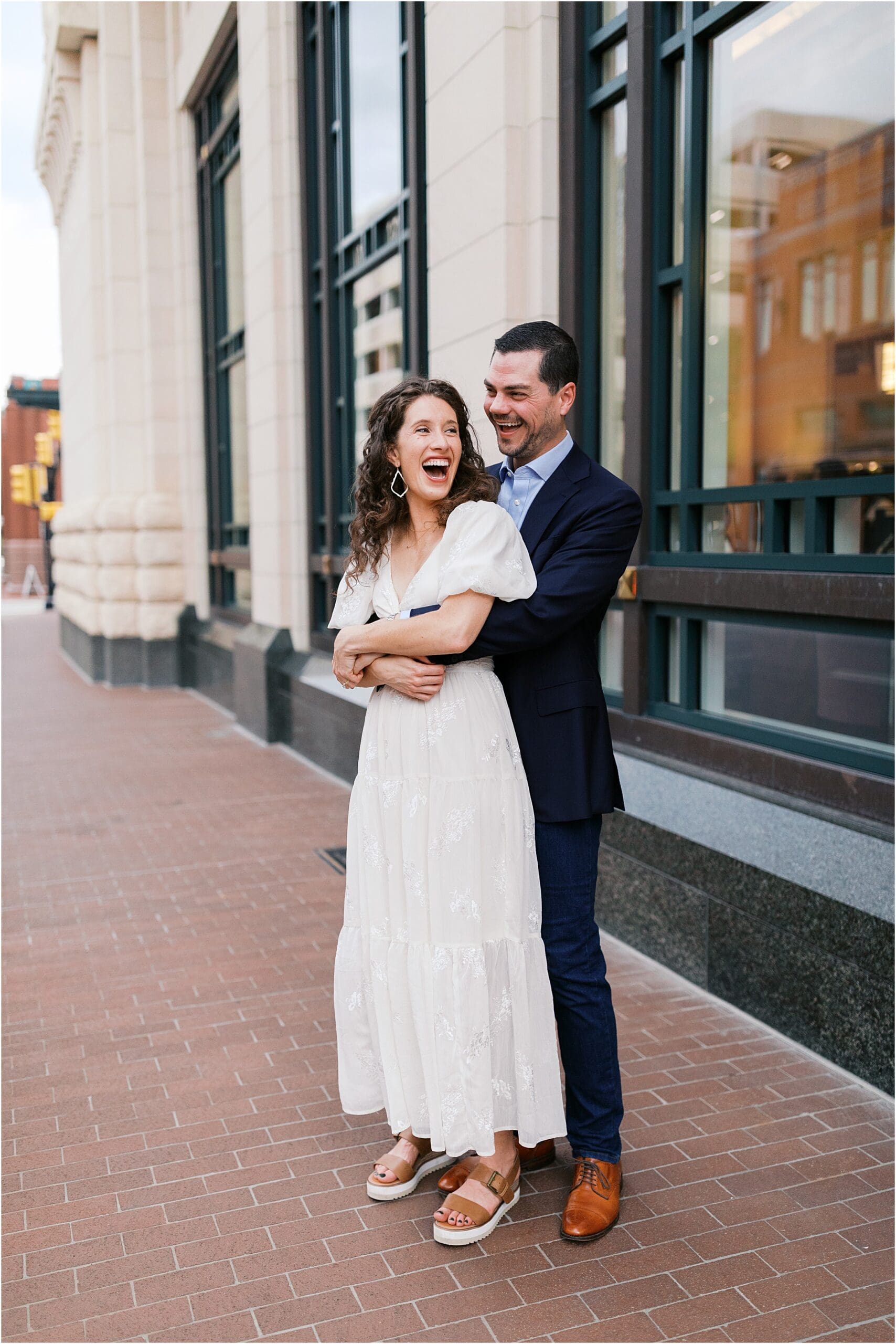 a couple laughing in front of bass hall fort worth texas on their engagement session 