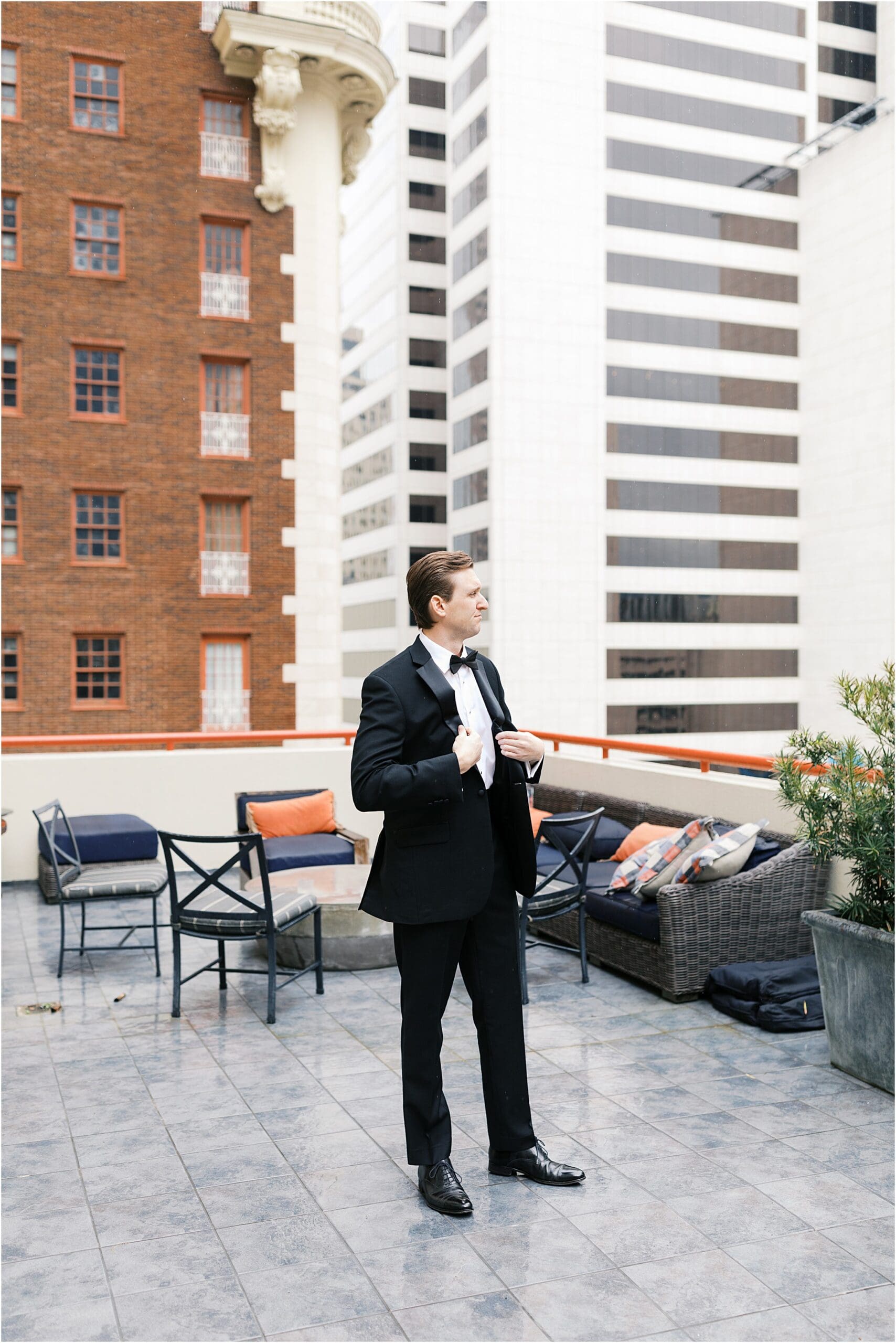 groom on the balcony of the adolphus hotel in dallas texas