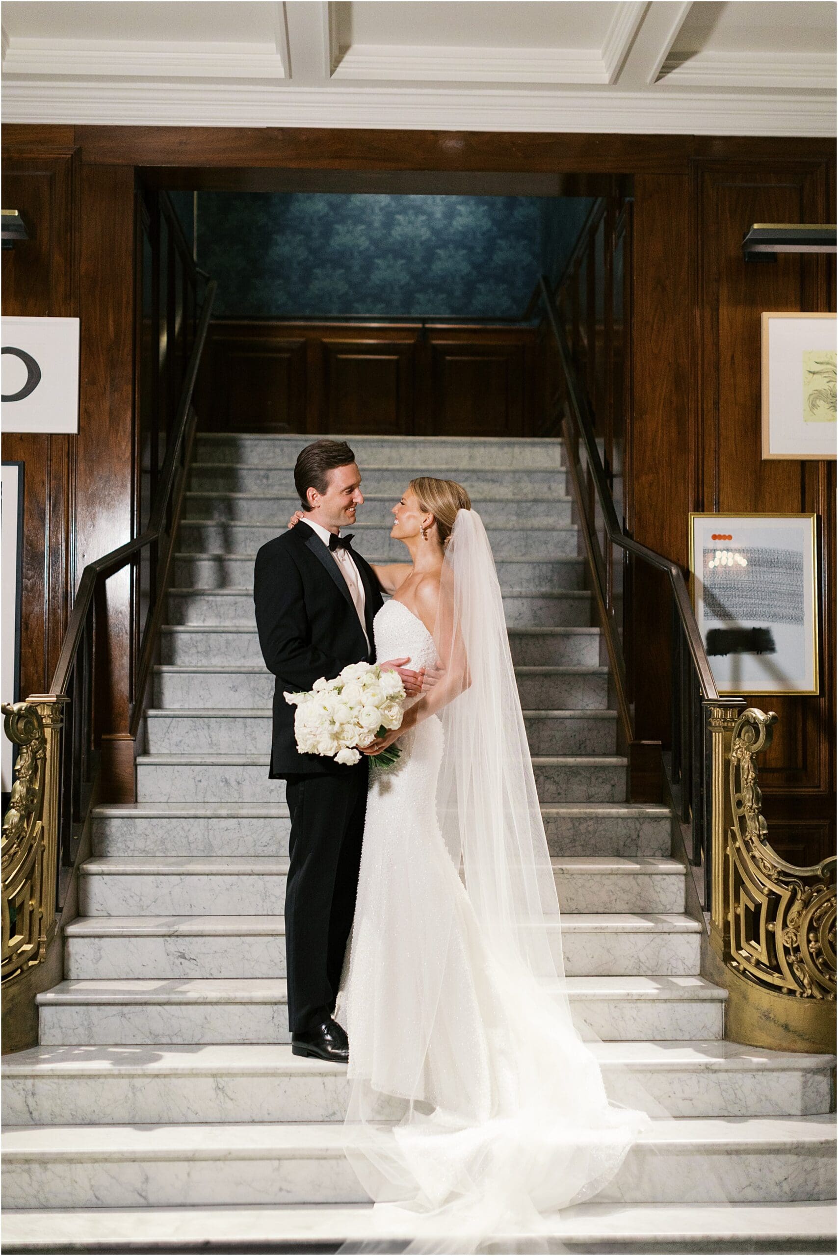 bride and groom on marble stairs in French Room lobby at Adolphus hotel in dallas texas
