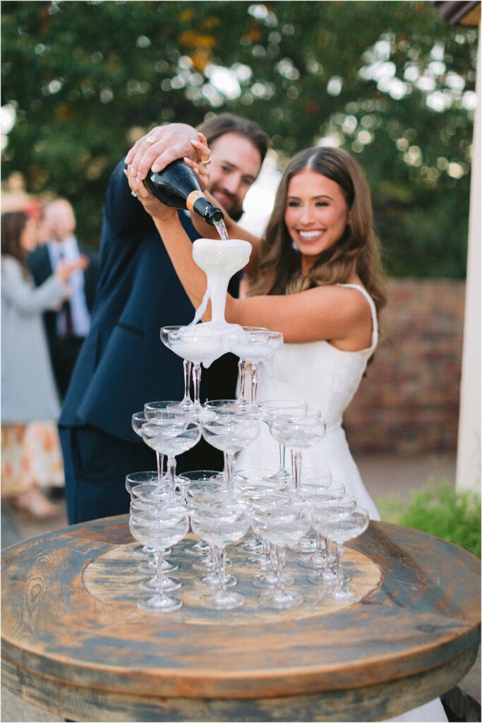 bride and groom with champagne tower at wedding reception at stoney ridge villa in fort worth texas
