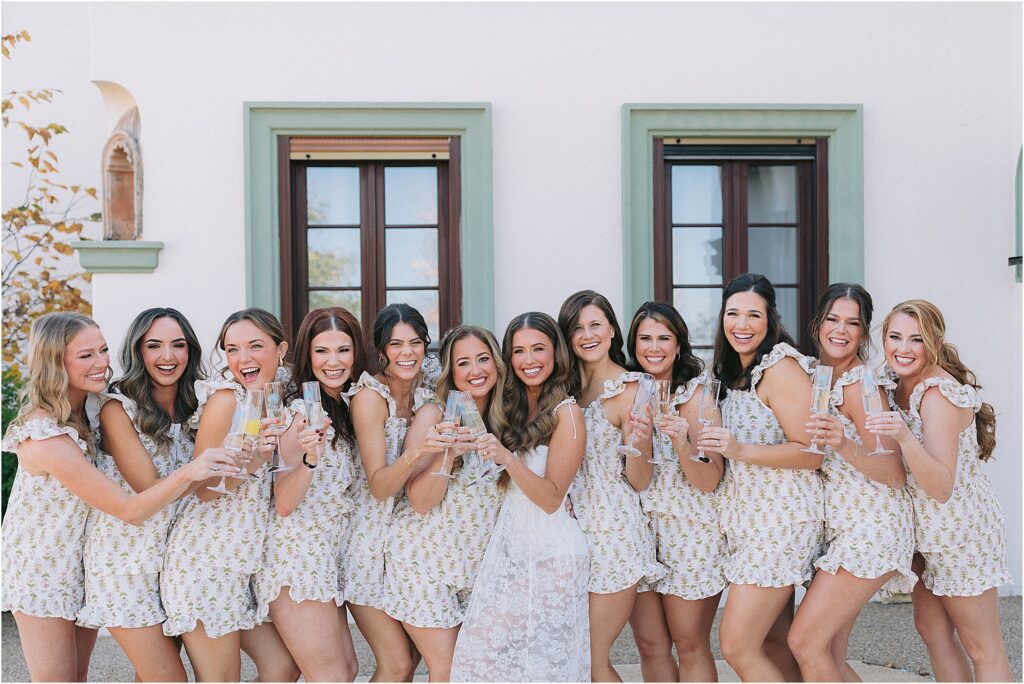 bride and bridesmaids holding monogramed champagne glasses with matching pajamas