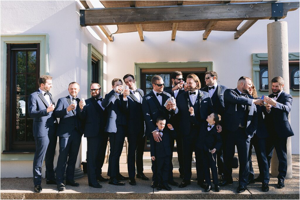 groomsmen outside of stoney ridge villa in fort worth texas cheering with beers