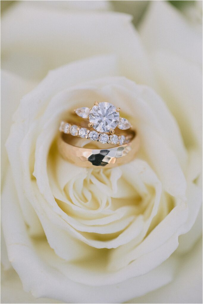 bride and groom's wedding rings in a white rose