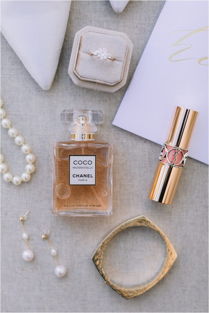 brides detail photo with Coco Chanel Paris perfume and pearl earrings 